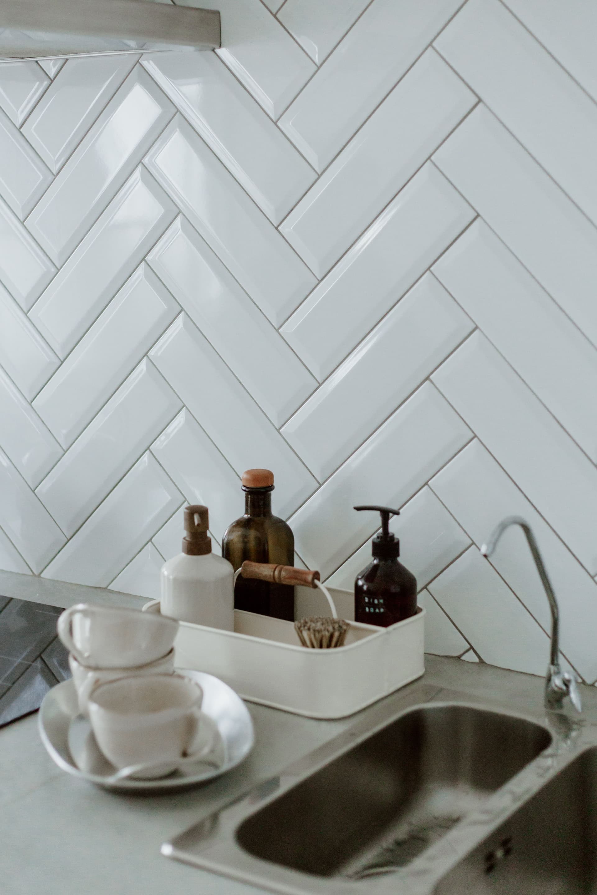 Organised kitchen counter with herringbone tile backsplash