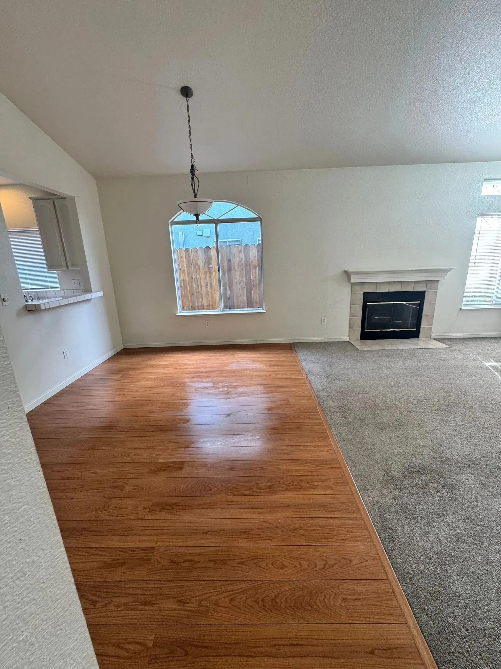 Clean residential living room with wood and carpet flooring