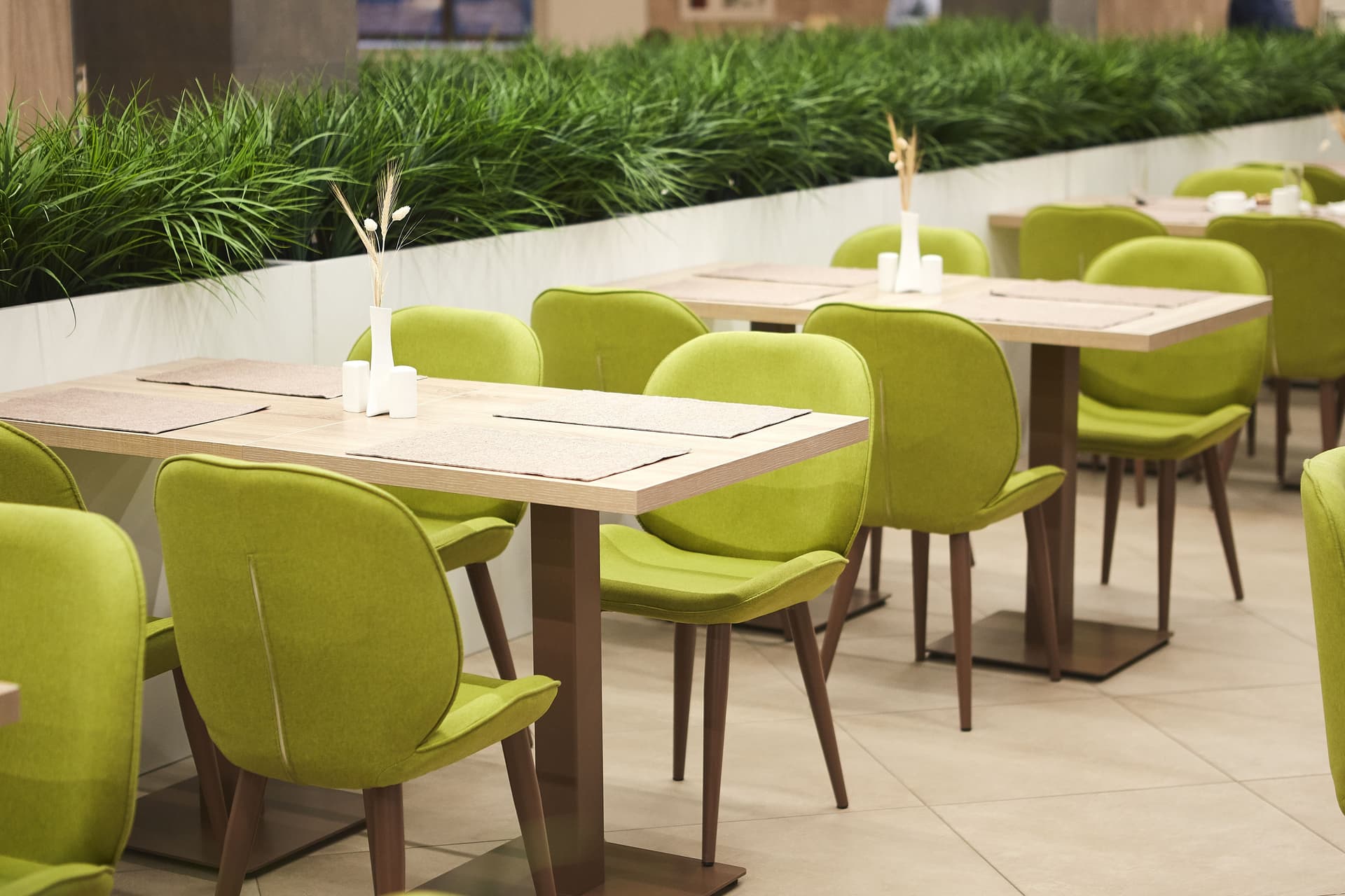 Restaurant dining area with set tables and green seating