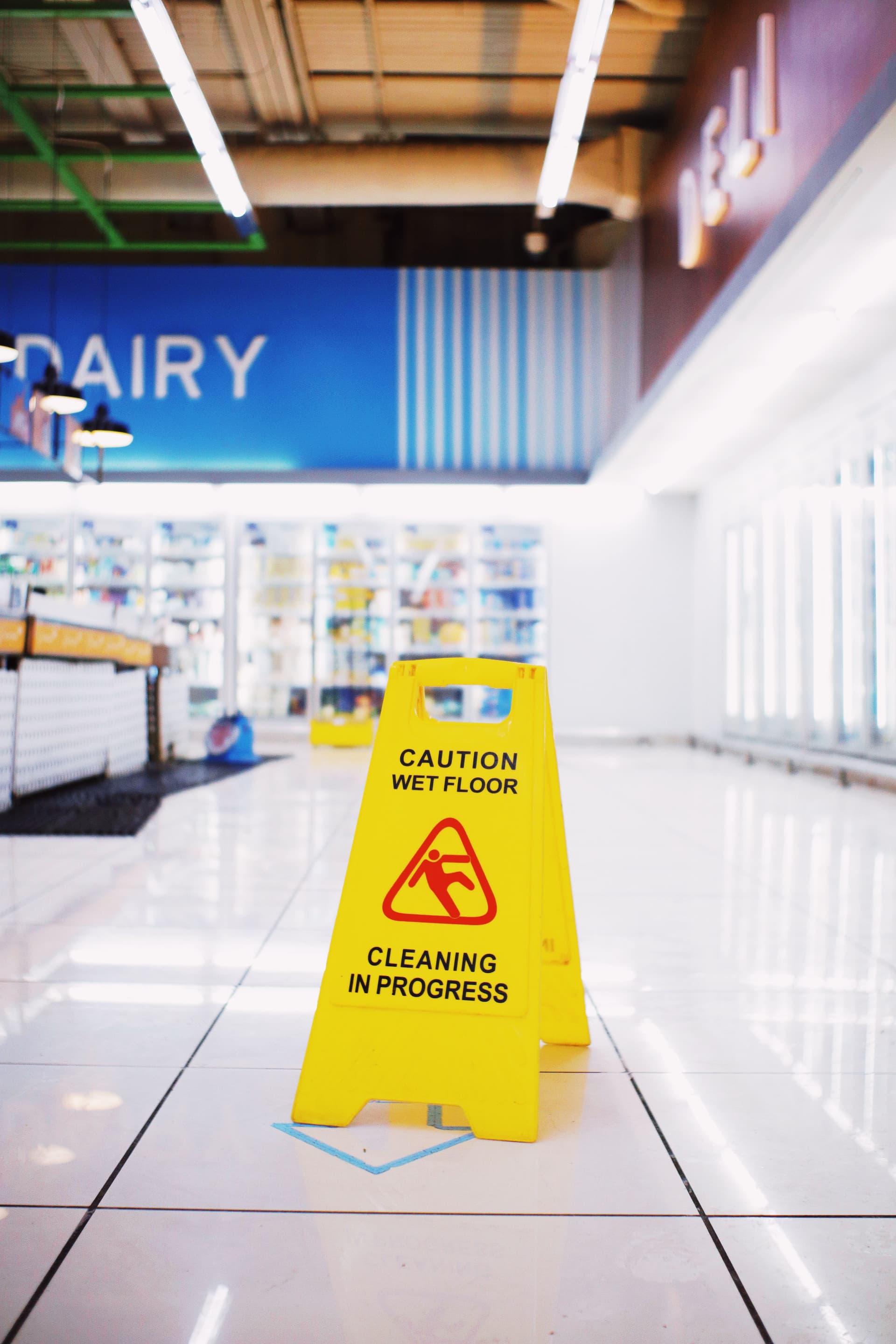 Wet floor caution sign in a retail supermarket aisle