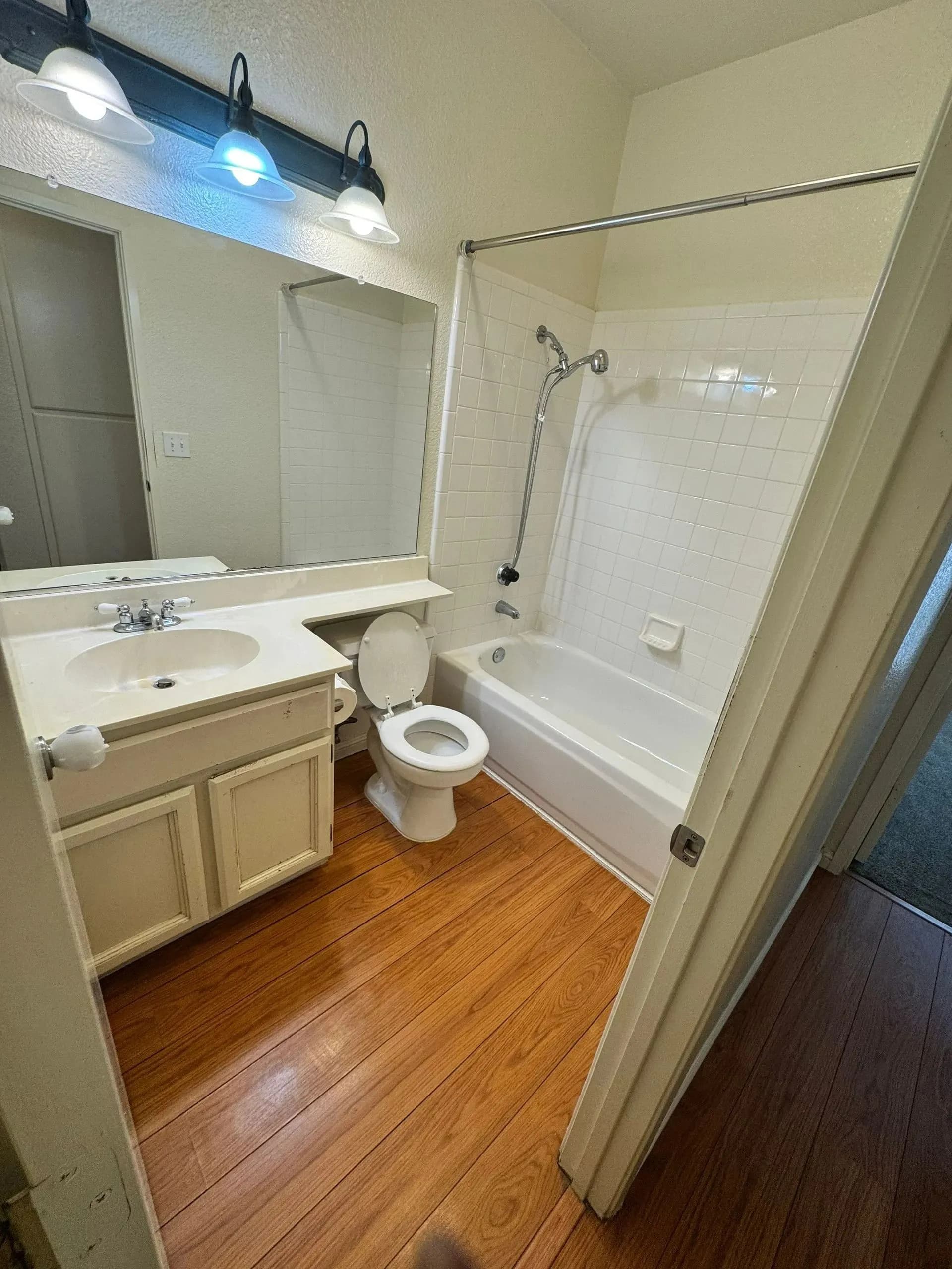 Clean residential bathroom with vanity, toilet and bathtub